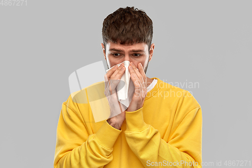 Image of man with paper napkin blowing nose