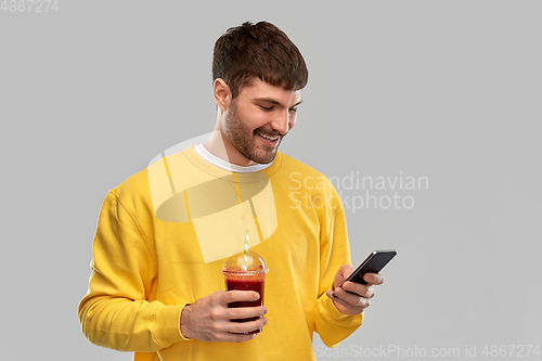Image of happy man with smartphone and tomato juice