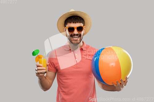 Image of happy man with orange juice and beach ball