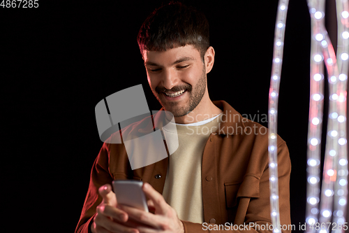 Image of happy smiling young man with smartphone