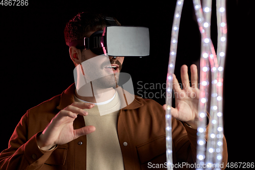 Image of happy man in vr glasses over black background