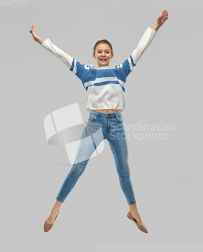 Image of smiling teenage girl in pullover jumping