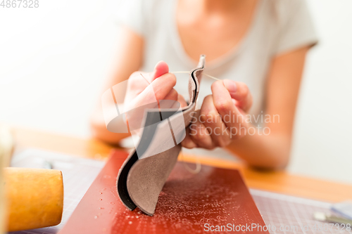 Image of Woman making leather bag