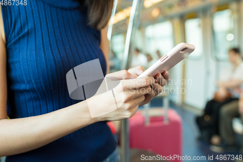 Image of Woman using mobile phone inside train compartment