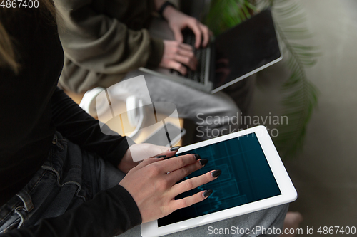 Image of Close up of two people, couple using smartphone, laptop, smartwatch, education and business concept, communication during self-insulation