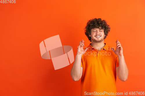 Image of Caucasian young man\'s monochrome portrait on orange studio background