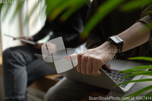 Image of Close up of two people, couple using smartphone, laptop, smartwatch, education and business concept, communication during self-insulation