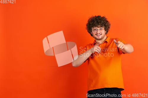 Image of Caucasian young man\'s monochrome portrait on orange studio background