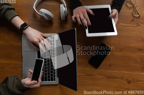 Image of Close up of two people, couple using smartphone, laptop, smartwatch, education and business concept. Communication during self-insulation, top view, copyspace