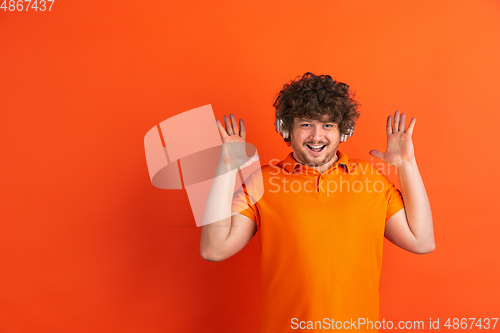 Image of Caucasian young man\'s monochrome portrait on orange studio background