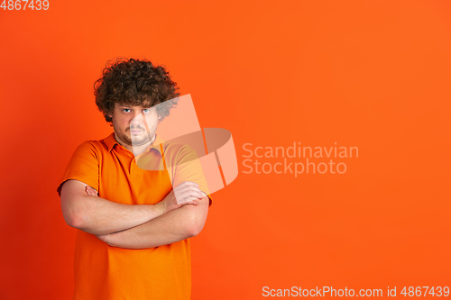 Image of Caucasian young man\'s monochrome portrait on orange studio background