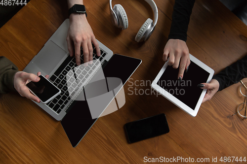 Image of Close up of two people, couple using smartphone, laptop, smartwatch, education and business concept. Communication during self-insulation, top view, copyspace