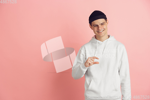 Image of Caucasian young man\'s modern portrait on pink studio background