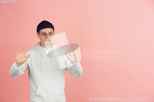 Image of Caucasian young man\'s modern portrait on pink studio background