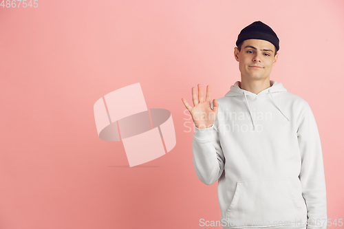 Image of Caucasian young man\'s modern portrait on pink studio background