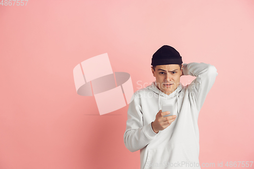 Image of Caucasian young man\'s modern portrait on pink studio background