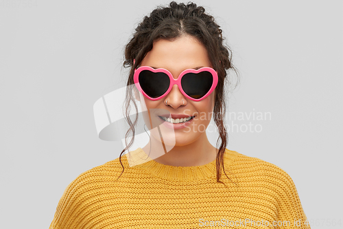 Image of smiling young woman in heart-shaped sunglasses