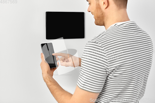 Image of man with smartphone and tablet pc at smart home