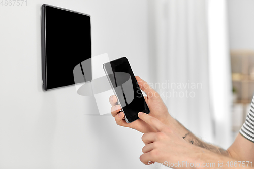 Image of man with smartphone and tablet pc at smart home