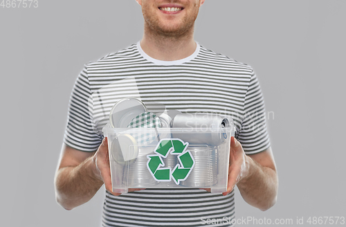 Image of smiling young man sorting metallic waste