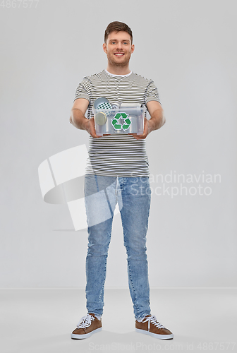 Image of smiling young man sorting metallic waste