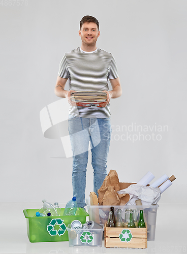 Image of smiling man sorting paper, metal and plastic waste