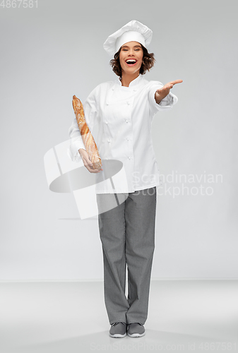 Image of happy female chef with french bread or baguette