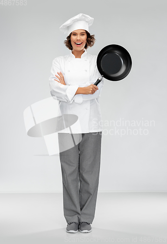 Image of smiling female chef in toque with frying pan