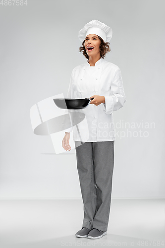 Image of smiling female chef in toque with frying pan