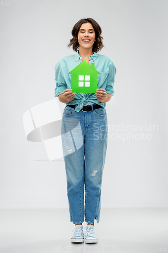 Image of smiling young woman holding green house