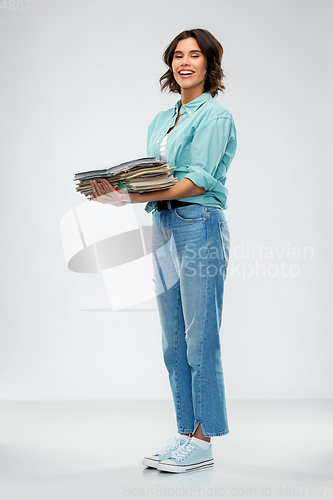 Image of smiling young woman sorting paper waste