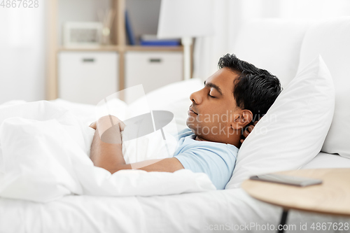 Image of indian man sleeping in bed at home