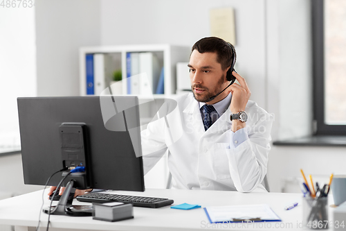 Image of male doctor with computer and headset at hospital