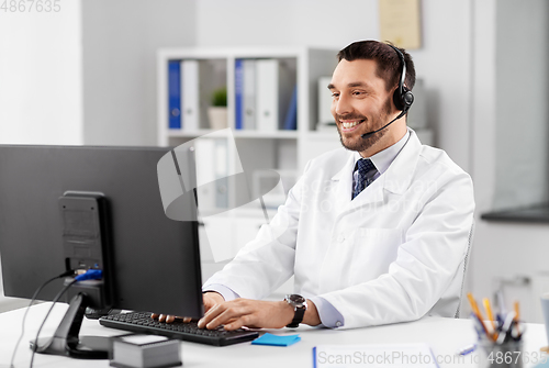 Image of happy doctor with computer and headset at hospital