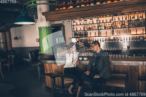 Image of Cheerful man and woman talking, enjoying a coffee at the coffee shop, cafe, bar