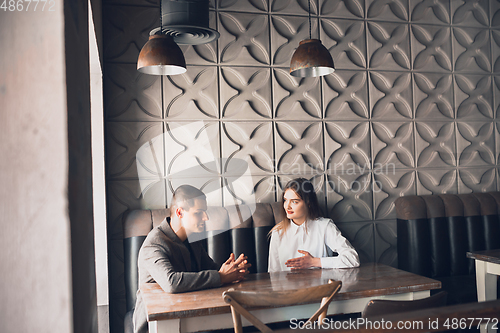 Image of Cheerful man and woman talking, discussing at the coffee shop, cafe