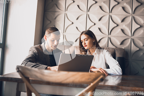 Image of Cheerful man and woman talking, working at the coffee shop, cafe