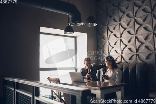 Image of Cheerful man and woman talking, enjoying a wine at the wine shop, cafe