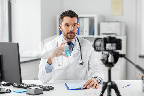 Image of doctor with hand sanitizer recording video blog