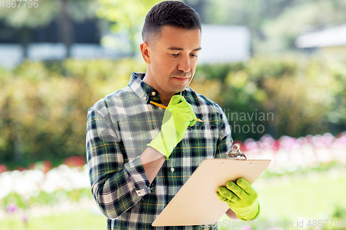 Image of man with clipboard at summer garden