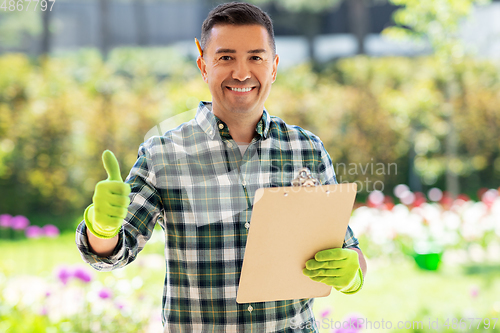 Image of man with clipboard showing thumbs up at garden