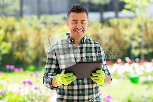 Image of happy man with tablet pc at summer garden