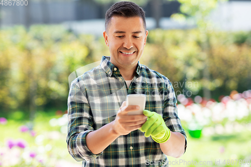 Image of happy man with smartphone at summer garden