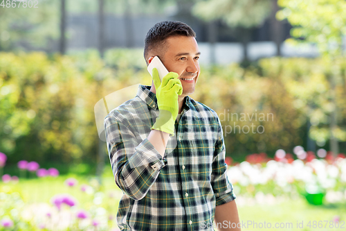 Image of happy man calling on smartphone at summer garden