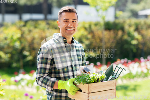 Image of happy man with tools in box at summer garden