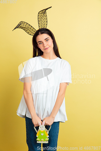 Image of Easter bunny woman with bright emotions on yellow studio background