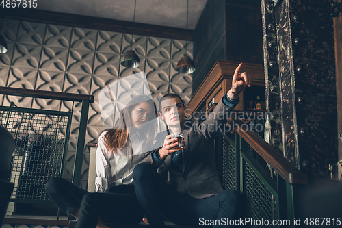 Image of Cheerful man and woman talking, enjoying, having fun at bar, cafe