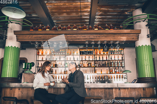 Image of Cheerful man and woman talking, enjoying a coffee at the coffee shop, cafe, bar