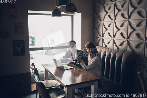 Image of Cheerful man and woman talking, enjoying a wine at the wine shop, cafe