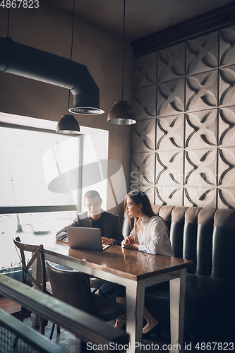 Image of Cheerful man and woman talking, working at the coffee shop, cafe